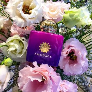 عطر زنانه آمواج مدل میتس در کنار گل های سازنده آن